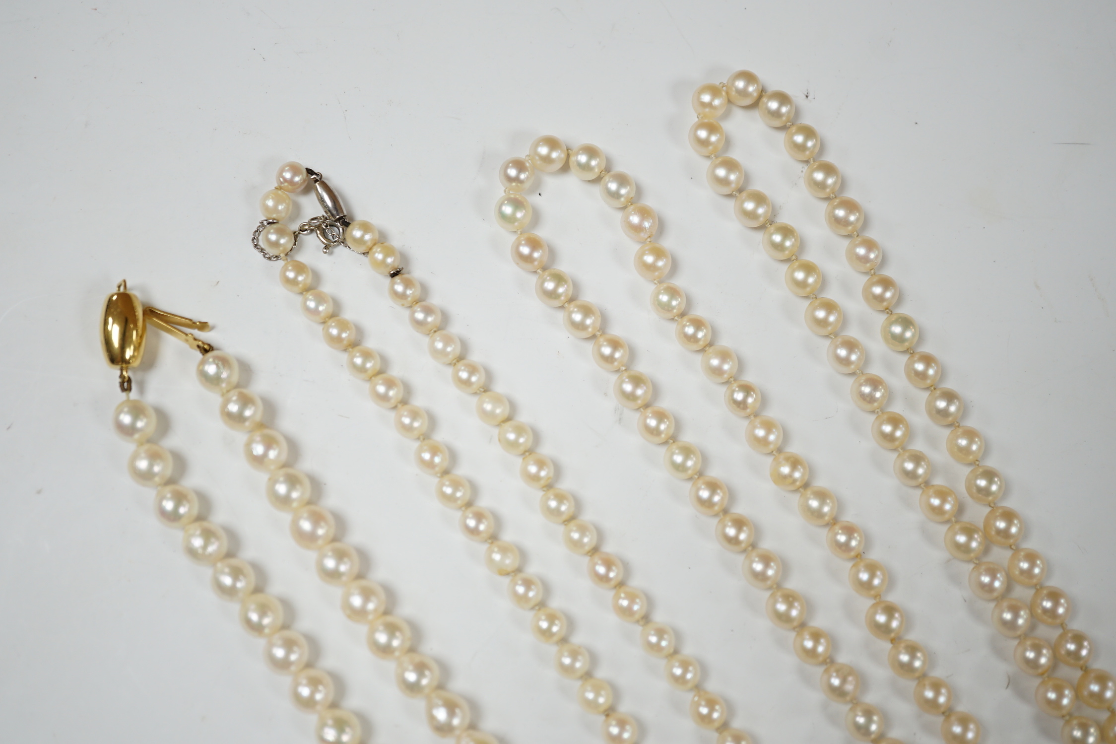 Three assorted modern single strand cultured pearl necklaces, one with 585 clasp, longest 76cm.